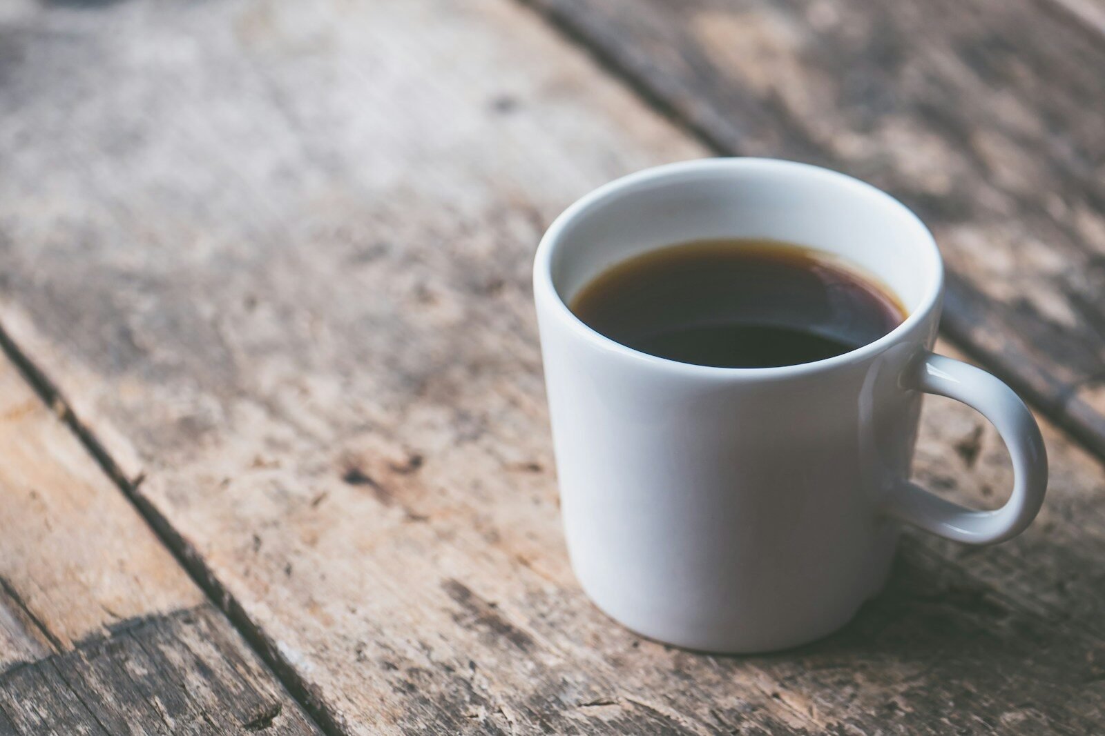 Cup of black coffee on a wooden table