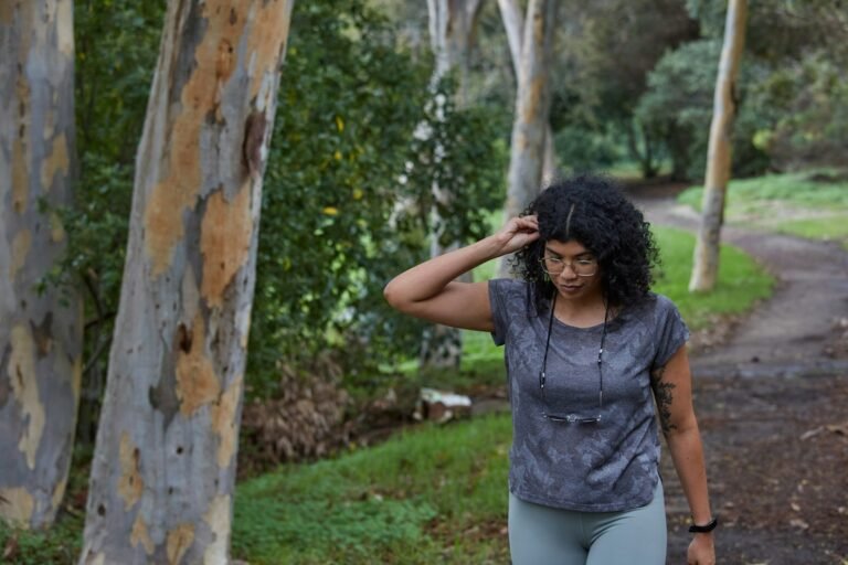 Woman out walking on a tree-lined park path