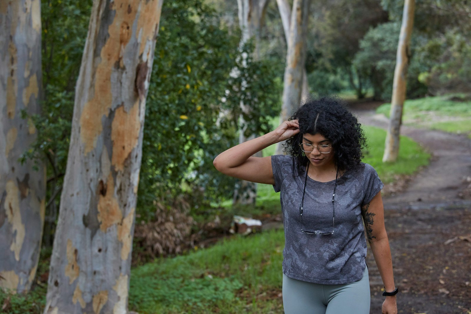 Woman out walking on a tree-lined park path