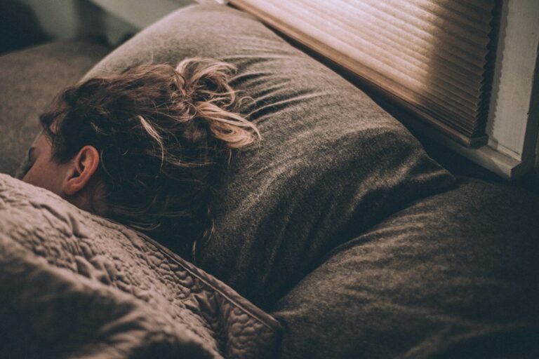 Woman sleeping peacefully in bed under blankets