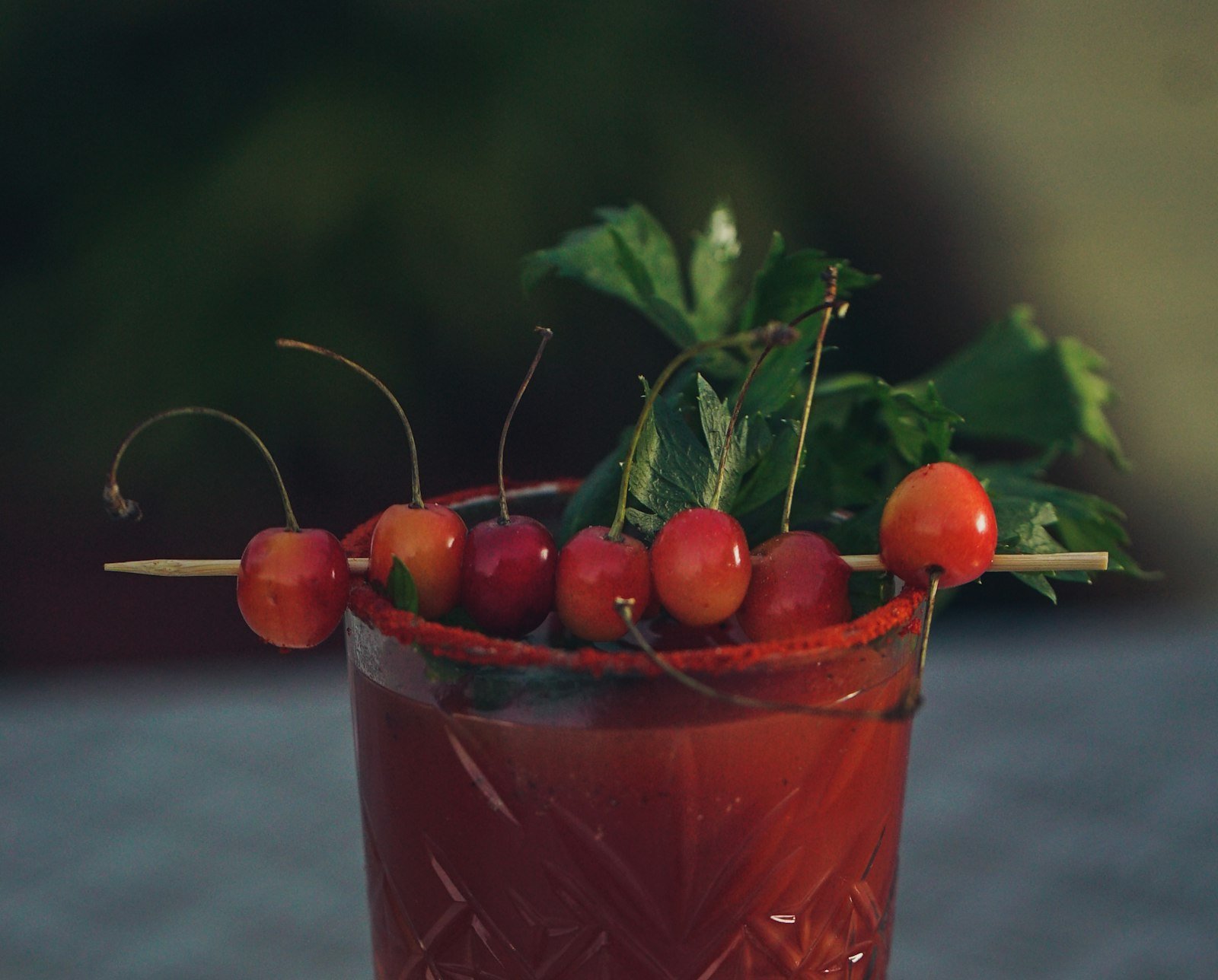 Glass of red cherry juice garnished with fresh cherries