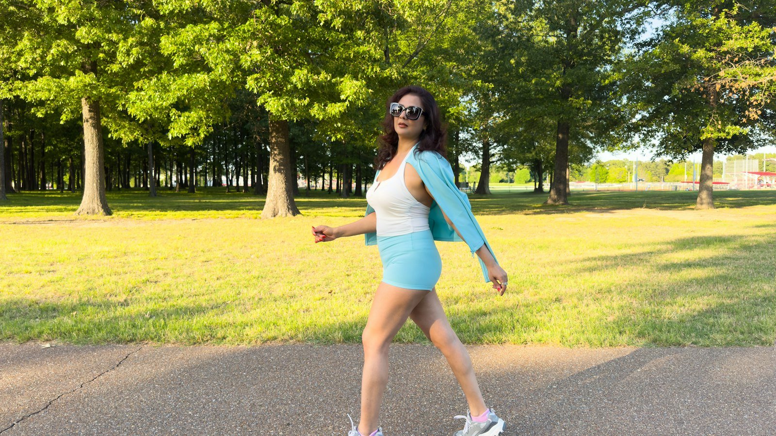 Woman walking on a paved path in a park